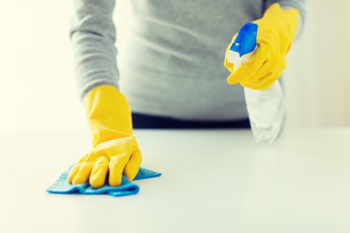 Sofa cleaning technician using extraction equipment in a safe workspace
