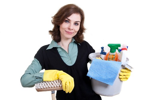 Cleaner removing oven racks and trays during a detailed appliance clean